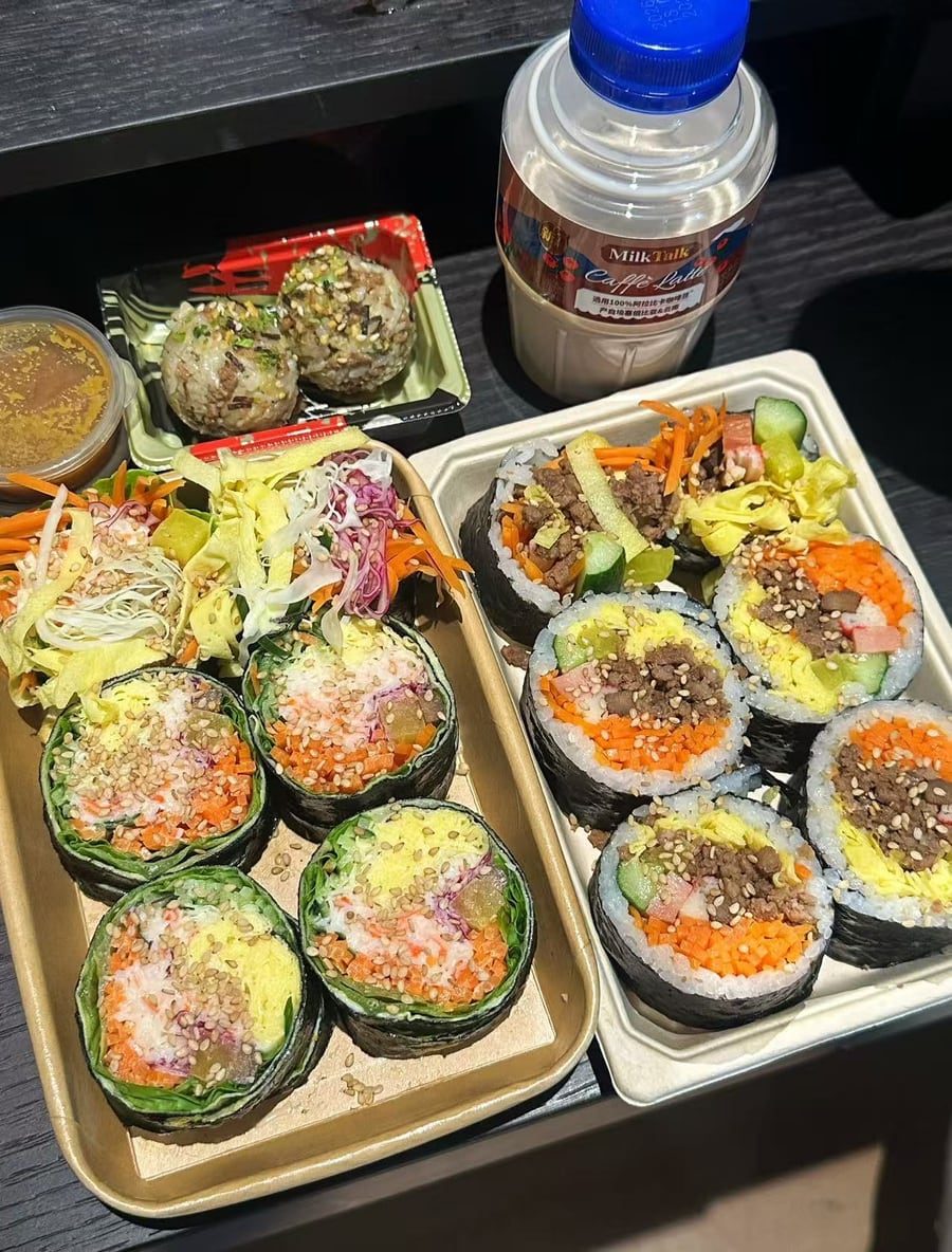 紫菜包饭、无米蔬菜卷、牛肉饭团与饮品组成的真实用餐场景