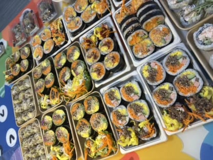 多份紫菜包饭按口味分盒摆满桌面的备餐场景